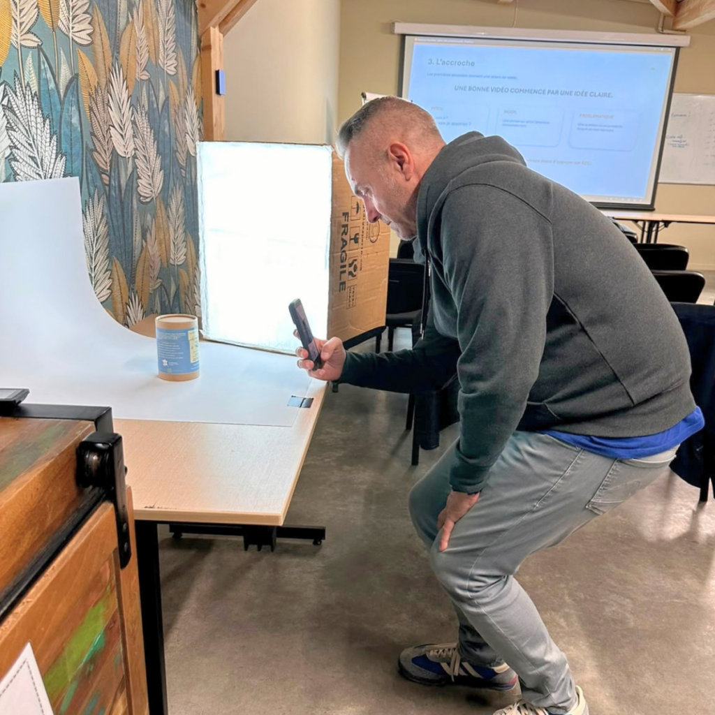 Participant filmant un produit avec son smartphone pendant l’atelier pratique MSD