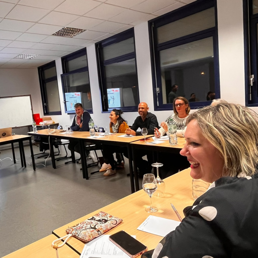 Participants souriants autour des tables pendant l’intervention de Laurent Remy.